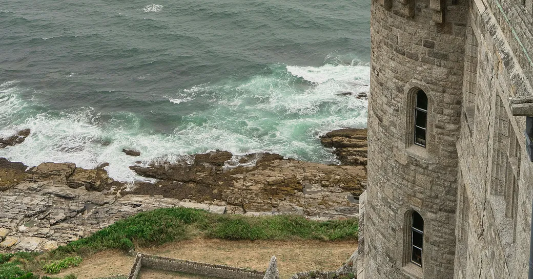 Crashing waves against the sea wall of an old castle